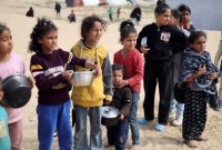Anak-anak Palestina yang terlantar menunggu untuk menerima makanan gratis di tenda kamp, ​​di tengah kekurangan makanan, di Rafah di Jalur Gaza selatan, Selasa (27/2/2024). [Reuters]