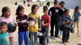 Anak-anak Palestina yang terlantar menunggu untuk menerima makanan gratis di tenda kamp, ​​di tengah kekurangan makanan, di Rafah di Jalur Gaza selatan, Selasa (27/2/2024). [Reuters]