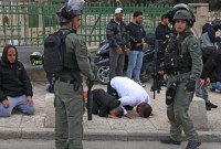 Polisi Israel berjaga-jaga di antara warga Palestina yang beribadah di kompleks Al Aqsa saat hari pertama Ramadan. [AFP/Ahmad Gharabli]