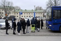 Petugas polisi berbicara dengan anggota keluarga siswa di sekolah komprehensif Viertola di Vantaa, Finlandia, Selasa (2/4/2024). [Lehtikuva/MARKKU ULANDER via REUTERS]