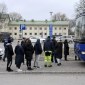 Petugas polisi berbicara dengan anggota keluarga siswa di sekolah komprehensif Viertola di Vantaa, Finlandia, Selasa (2/4/2024). [Lehtikuva/MARKKU ULANDER via REUTERS]