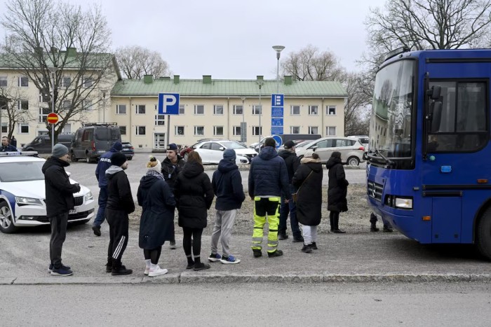 Petugas polisi berbicara dengan anggota keluarga siswa di sekolah komprehensif Viertola di Vantaa, Finlandia, Selasa (2/4/2024). [Lehtikuva/MARKKU ULANDER via REUTERS]