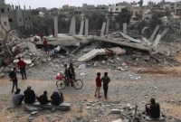 Warga Palestina memeriksa kerusakan sebuah bangunan setelah pemboman Israel semalaman di Rafah di Jalur Gaza selatan [AFP/Said Khatib]