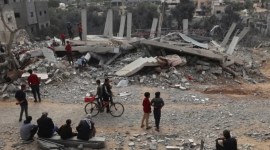 Warga Palestina memeriksa kerusakan sebuah bangunan setelah pemboman Israel semalaman di Rafah di Jalur Gaza selatan [AFP/Said Khatib]