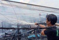 Petugas damkar Kota Palangka Raya memadamkan kobaran api yang melalap bangunan pemukiman warga Flamboyan Bawah, Senin (20/5/2024). [ANTARA/Adi Wibowo] 
