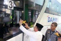 Kepala Kemenkumham Kalsel Taufiqurrakhman menempelkan stiker Immigration Clearance pada bus yang membawa jamaah ke Bandara Syamsudin Noor di Banjarbaru, Minggu (12/5/2024). [ANTARA/Firman]
