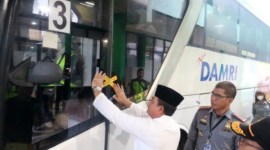 Kepala Kemenkumham Kalsel Taufiqurrakhman menempelkan stiker Immigration Clearance pada bus yang membawa jamaah ke Bandara Syamsudin Noor di Banjarbaru, Minggu (12/5/2024). [ANTARA/Firman]