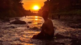 Seorang pengunjung menikmati panorama matahari tenggelam saat matahari terbenam di objek wisata Lok Tampang Desa Taratau Kecamatan Jaro, Kabupaten Tabalong, Kalimantan Selatan beberapa waktu lalu. [ANTARA/Herlina Lasmianti]