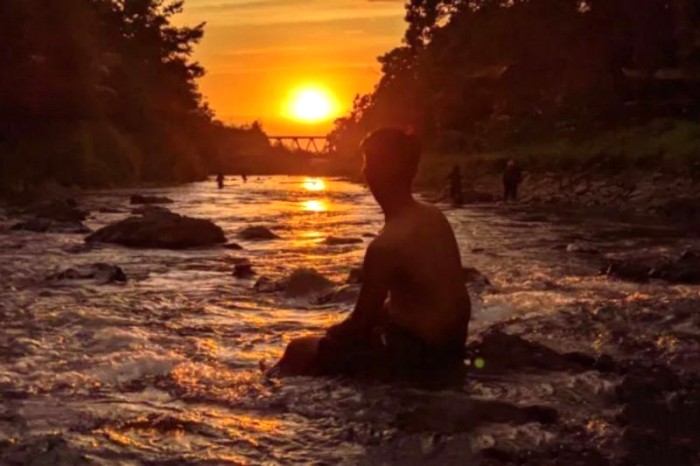 Seorang pengunjung menikmati panorama matahari tenggelam saat matahari terbenam di objek wisata Lok Tampang Desa Taratau Kecamatan Jaro, Kabupaten Tabalong, Kalimantan Selatan beberapa waktu lalu. [ANTARA/Herlina Lasmianti]