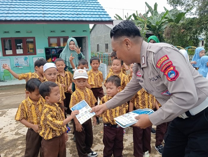 Anggota Satlantas Polres Balangan memberikan buku bergambar tentang rambu lalu lintas sebagai alat peraga edukasi kepada siswa TK Cempaka, Kecamatan Paringin Selatan, (SuarIndonesia/Adv)