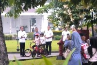 Presiden Jokowi dan cucunya Jan Ethes melihat warga yang antri menerima sembako di Istana Kepresidenan Yogyakarta atau Gedung Agung, Jumat (24/5) sore. [SuaraJogja/Putu Ayu P]