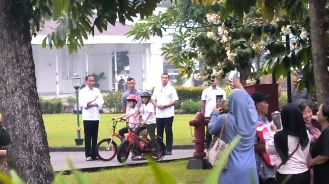 Presiden Jokowi dan cucunya Jan Ethes melihat warga yang antri menerima sembako di Istana Kepresidenan Yogyakarta atau Gedung Agung, Jumat (24/5) sore. [SuaraJogja/Putu Ayu P]