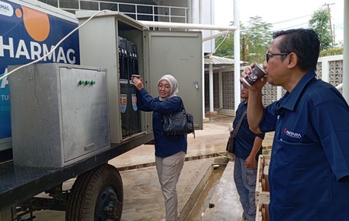 Dua pengunjung Kota Nusantara sedang mengambil dan menikmati air embun di kawasan HPK IKN. [ANTARA/M Ghofar]
