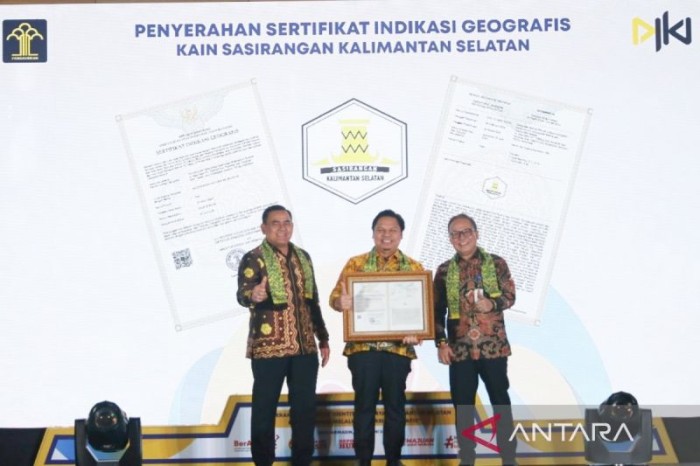 Staf Ahli Menteri Hukum dan Hak Asasi Manusia Bidang Ekonomi Lucky Agung menyerahkan sertifikat Indikasi Geografis Kain Sasirangan kepada Sekretaris Daerah Provinsi Kalsel Roy Rizali Anwar. [ANTARA/Firman]
