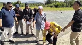Pejabat (PJ) Bupati Tanah Laut, Syamsir Rahman (berjongkok) menunjukan jalan di lokasi pengukuran untuk pengaspalan tersebut, Jumat,(14/6/2024). (SuarIndonesia/Ist)