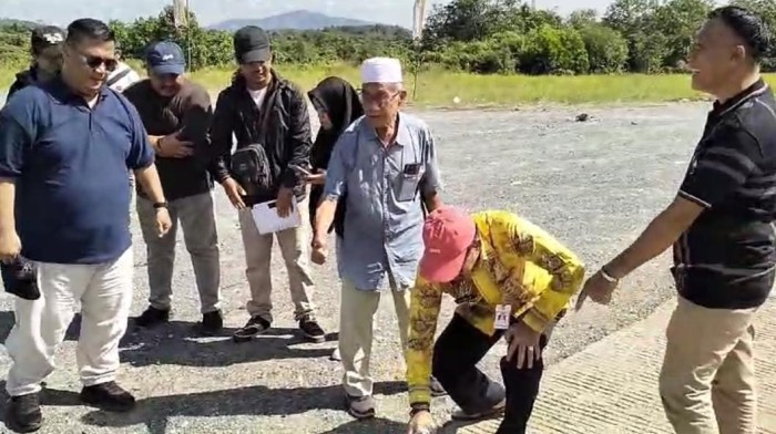 Pejabat (PJ) Bupati Tanah Laut, Syamsir Rahman (berjongkok) menunjukan jalan di lokasi pengukuran untuk pengaspalan tersebut, Jumat,(14/6/2024). (SuarIndonesia/Ist)