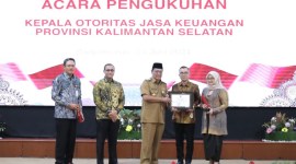 Gubernur  saat menyerahkan cindra mata pada mantan Kepala OJK Kalsel Darmansyah yang digantikan Agus Maiyo resmi menjabat Kepala OJK Kalsel. Foto/humasojk
