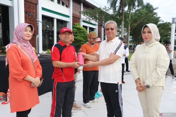 Pj Gubernur Kalbar Harisson membagikan tumbler kepada ASN yang ada di lingkungan Pemprov Kalbar pada kegiatan peringatan Hari Lingkungan Hidup Sedunia yang dilaksanakan di halaman Kantor Gubernur Kalbar, Jumat (7/6/2024). [ANTARA/Rendra Oxtora]