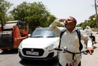Seorang pria meminum minuman dingin yang ditawarkan oleh penduduk setempat pada hari musim panas saat gelombang panas terjadi di Narela, New Delhi, India, Minggu (2/6/2024). [Reuters]