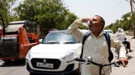 Seorang pria meminum minuman dingin yang ditawarkan oleh penduduk setempat pada hari musim panas saat gelombang panas terjadi di Narela, New Delhi, India, Minggu (2/6/2024). [Reuters]