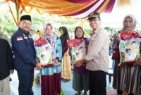 Sekda Kalteng Nuryakin (kiri) dan Sekda Barito Timur Panahan Moetar secara simbolis menyerahkan sembako kepada masyarakat Ampah pada Gerakan Pangan Murah (GPM) atau pasar murah di halaman SMAN 1 Dusun Tengah, di Ampah Kota Kecamatan Dusun Tengah, Kamis (13/6/2014). [ANTARA/HO-Diskominfo Barito Timur]