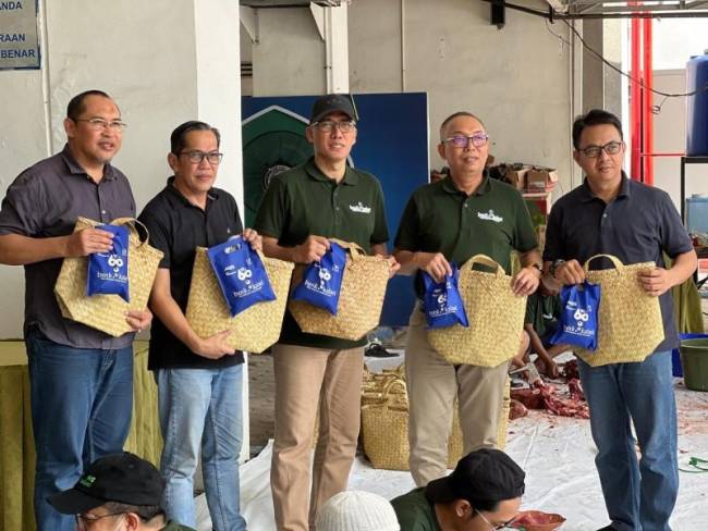 Direktur Utama Bank Kalsel Fachrudin di dampingi Komisaris Bank Kalsel Rizal Akbar Sarupi, Kepala Divisi Sekretaris Perusahaan Firmansyah, Kepala Divisi Perencanaan dan Kinerja Izhar dan Kepala Divisi Operasional Ahmad Riyadi saat menunjukan bakul purun tempat daging kurban. (Foto: Humasbankkalsel)