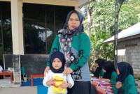 Seorang ibu mengantarkan sang anak memeriksakan kesehatan dan memberi susu tambahan di Desa Lok Batung, Kecamatan Paringin, Kabupaten Balangan, Kalimantan Selatan, Jumat (19/7/2024). [ANTARA/Herlina Lasmianti]