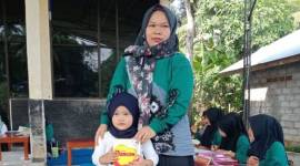Seorang ibu mengantarkan sang anak memeriksakan kesehatan dan memberi susu tambahan di Desa Lok Batung, Kecamatan Paringin, Kabupaten Balangan, Kalimantan Selatan, Jumat (19/7/2024). [ANTARA/Herlina Lasmianti]