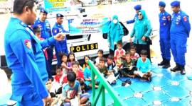 

Anggota Satpolairud Polresta Banjarmasin memberikan edukasi kepada anak pesisir sungai saat berada di kapal perpustakaan terapung. [ANTARA/Gunawan Wibisono]