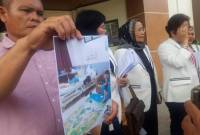 Lando Situmorang menunjukan foti istrinya saah kondisi masih sehat bersama anaknya. (SuarIndoesia/ZI)