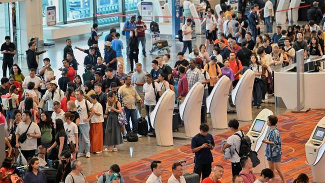 Penampakan antrean mengular di Bandara Changi Singapura yang terdampak gangguan internet global. [REUTERS/Caroline Chia]