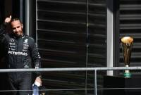 Pebalap Inggris Lewis Hamilton dari tim Mercedes AMG Petronas F1 melambaikan tangan untuk upacara podium setelah Grand Prix Belgia di Sirkuit Spa-Francorshamps, Minggu (28/7/2024). (AFP/SIMON WOHLFAHRT)