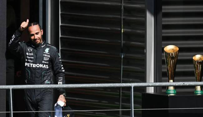 Pebalap Inggris Lewis Hamilton dari tim Mercedes AMG Petronas F1 melambaikan tangan untuk upacara podium setelah Grand Prix Belgia di Sirkuit Spa-Francorshamps, Minggu (28/7/2024). (AFP/SIMON WOHLFAHRT) 