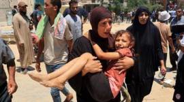 Seorang wanita Palestina membawa seorang anak yang terluka ke rumah sakit Nasser di Khan Yunis pada Sabtu (13/7/2024). [AFP/EYAD BABA]
