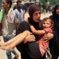 Seorang wanita Palestina membawa seorang anak yang terluka ke rumah sakit Nasser di Khan Yunis pada Sabtu (13/7/2024). [AFP/EYAD BABA]