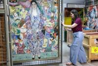 Nathalie Andrijasevic, asisten kurator di Museum Seni Tel Aviv, menangani lukisan karya pelukis Austria Gustav Klimt yang dipindahkan ke ruang bawah tanah di museum di Tel Aviv, Selasa (13/8/2024). (AFP)
