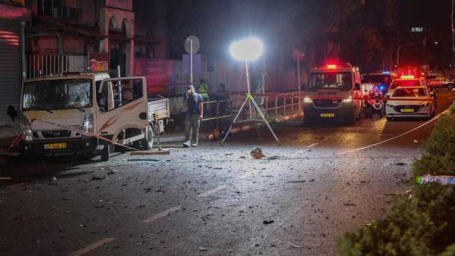 Petugas keamanan dan tanggap darurat Israel menutup lokasi ledakan bom di Tel Aviv, Minggu (18/8/2024) waktu setempat. (AFP)