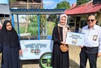 Afriani menerima bantuan rombong berkah dari Bank Kalsel yang langsung diserahkan Direktur UPZ H. Muhammad Fajri Muhtadi.(Foto: Reprohumasbankalsel)