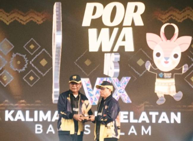 Ketua Umum PWI Pusat Hendry Ch Bangun menyerahkan langsung sebuah plakat berwarna kuning keemasan itu kepada Gubernur Kalsel., H Sahbirin Noor. (SuarIndonesia/Ist)