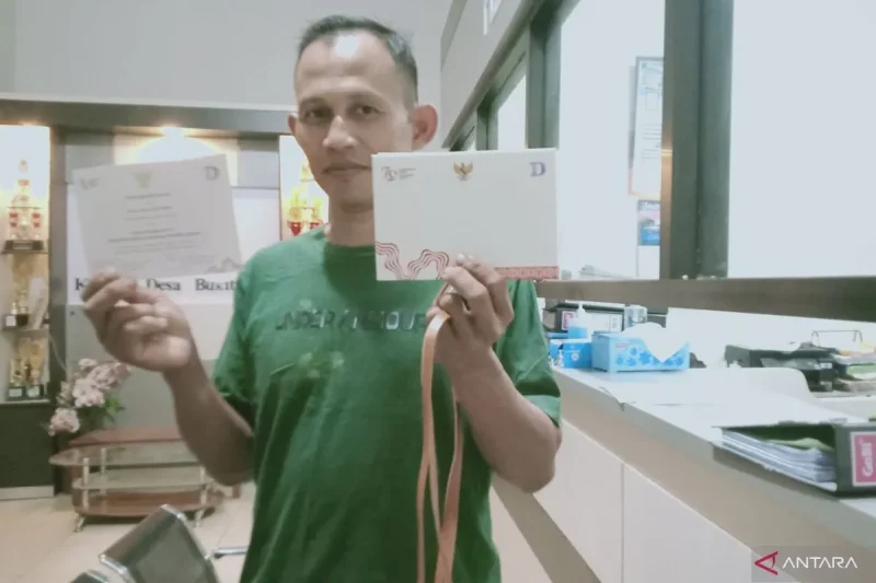 Salah satu warga,, Asep Suparman menunjukkan undangan upacara kemerdekaan di Istana Garuda Kota Nusantara pada 17 Agustus 2024 (SuarIndonesia/ANTARA/Nyaman Bagus Purwaniawan)