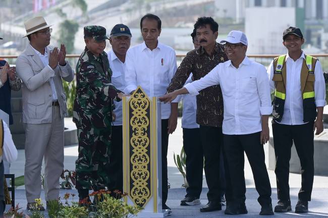 Presiden Joko Widodo (tengah), didampingi Menko Polhukam Hadi Tjahjanto (ketiga kanan), Menteri PUPR Basuki Hadimuljono (ketiga kiri), Mensesneg Pratikno (kedua kanan), Wakil Menteri ATR/BPN Raja Juli Antoni (kanan), Panglima TNI Jenderal TNI Agus Subiyanto (kedua kiri), Kurator Pembangunan IKN Ridwan Kamil (kiri) menekan bel saat peresmian Taman Kusuma Bangsa di Ibu Kota Nusantara (IKN), Penajam Paser Utara, Kalimantan Timur, Senin (12/8/2024). Taman Kusuma Bangsa dirancang sebagai tempat renungan suci dan penghormatan kepada para pahlawan bangsa. (ANTARA FOTO/Fauzan)