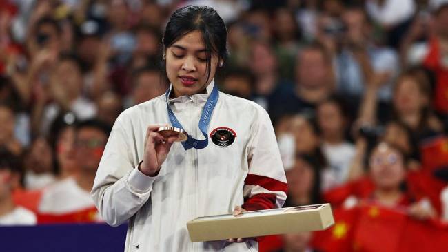 Gregoria Mariska Tunjung melihat ke arah medali perunggu yang didapatnya dalam seremoni penyerahan medali tunggal putri badminton Olimpiade 2024 Paris di Porte de La Chapelle Arena, Paris, Senin (5/8/2024). (REUTERS/Ann Wang)