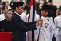 Presiden Joko Widodo (tengah) selaku pembina upacara menyematkan lencana kepada anggota Paskibraka 2024 asal Sumatera Utara Violetha Agryka Sianturi dalam pengukuhan Paskibraka Tingkat Pusat 2024 di Istana Negara, Ibu Kota Nusantara (IKN), Kalimantan Timur, Selasa (13/8/2024). (ANTARA FOTO/SIGID KURNIAWAN)