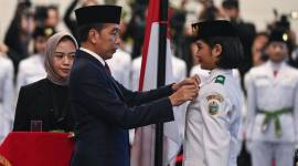 Presiden Joko Widodo (tengah) selaku pembina upacara menyematkan lencana kepada anggota Paskibraka 2024 asal Sumatera Utara Violetha Agryka Sianturi dalam pengukuhan Paskibraka Tingkat Pusat 2024 di Istana Negara, Ibu Kota Nusantara (IKN), Kalimantan Timur, Selasa (13/8/2024). (ANTARA FOTO/SIGID KURNIAWAN)