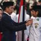 Presiden Joko Widodo (tengah) selaku pembina upacara menyematkan lencana kepada anggota Paskibraka 2024 asal Sumatera Utara Violetha Agryka Sianturi dalam pengukuhan Paskibraka Tingkat Pusat 2024 di Istana Negara, Ibu Kota Nusantara (IKN), Kalimantan Timur, Selasa (13/8/2024). (ANTARA FOTO/SIGID KURNIAWAN)
