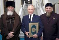 Presiden Rusia Vladimir Putin memeluk Al-Qur'an saat berfoto dengan pemimpin Chechnya Ramzan Kadyrov (kanan) dan Mufti Chechnya Sheikh Salah-Hadzhi Mezhiev (kiri). (AFP/VYACHESLAV PROKOFYEV)