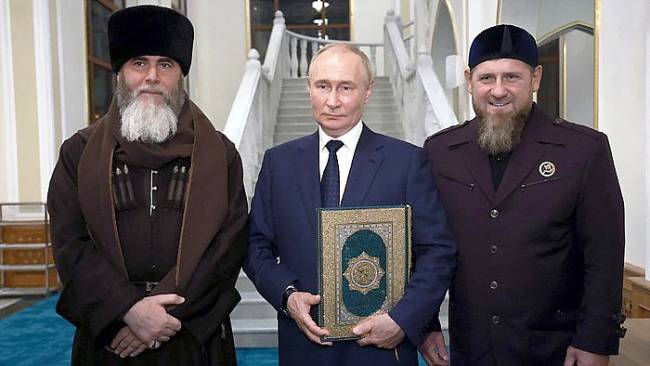 Presiden Rusia Vladimir Putin memeluk Al-Qur'an saat berfoto dengan pemimpin Chechnya Ramzan Kadyrov (kanan) dan Mufti Chechnya Sheikh Salah-Hadzhi Mezhiev (kiri). (AFP/VYACHESLAV PROKOFYEV)