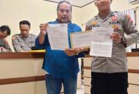 Robert Hendra Sulu SH MH dengan buikti laporan polisi. (SuarIndonesia/Ist)