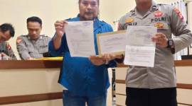 Robert Hendra Sulu SH MH dengan buikti laporan polisi. (SuarIndonesia/Ist)