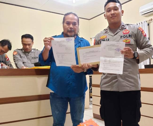 Robert Hendra Sulu SH MH dengan buikti laporan polisi. (SuarIndonesia/Ist)